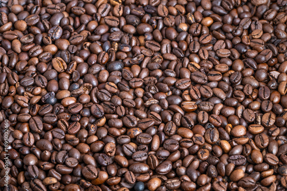 Fototapeta premium Dense pile roasted coffee beans bulk, warehouse supply context with consistent roast level and readyforpackaging appearance ideal for commerce and distribution imagery