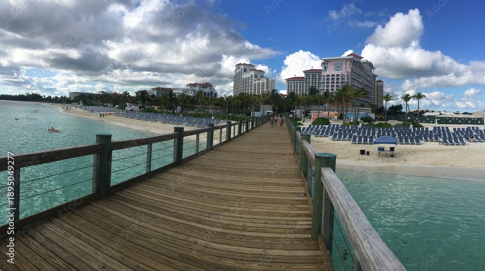 Obraz premium Beachfront Boardwalk with Resort and Chairs