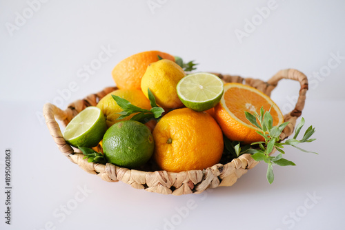 Wicker Basket with Citrus Fruits on White