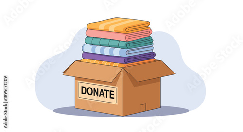 Cardboard box labeled donate filled with a stack of neatly folded colorful clothes for charity on a light blue background.