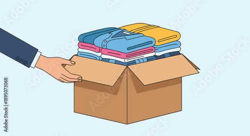 Person in a professional suit places neatly folded blue and pink shirts into a cardboard box for organized storage or shipping.
