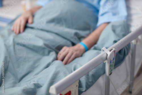 Φωτογραφία Middle aged Caucasian man lying in hospital bed with hand resting on blanket, we