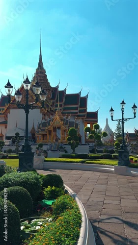 Wallpaper Mural A majestic view of the Grand Palace in Bangkok, Thailand, showcasing its ornate golden architecture and serene gardens under a clear blue sky Torontodigital.ca