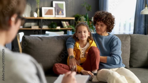 Wallpaper Mural Over shoulder shot of female psychotherapist writing notes on clipboard while listening to mother and young boy sharing emotions during parent child therapy session at office, AI generated video Torontodigital.ca