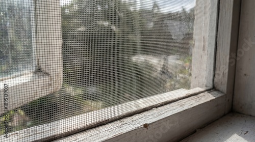 Close Up Of Old Window Screen With Peeling White Paint And Mesh Texture