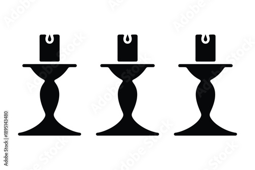 Three black candle holders with unlit candles on a white background