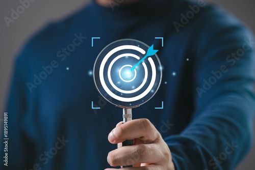 Magnifying glass highlighting a target with an arrow hitting the center, representing goal achievement, business focus, strategic planning, accuracy, performance improvement, and success measurement.