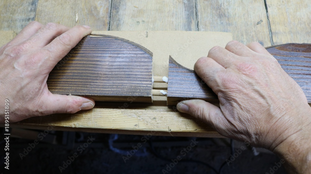Φωτογραφία The carpenter joins two sawn wooden parts from a piece of furniture decor by glu