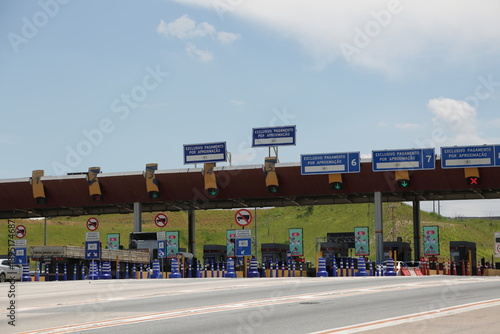 Praça de pedágio em rodovia movimentada, simbolizando mobilidade, transporte, logística e conexão entre cidades. Conceito de tráfego, infraestrutura moderna, viagens, deslocamento e fluxo econômico.