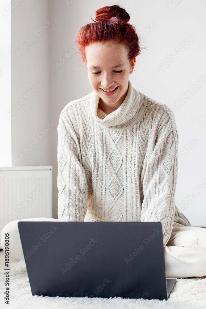 © Tatyana Gladskih - Smiling Teen Girl with red-haired communicates online in a live chat indoors