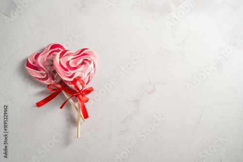 Valentine's Day festive background. Heart-shaped lollipops on grey background with copy space. Love concept