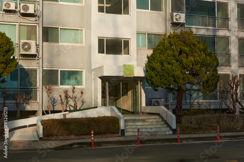 Apartment Building Entrance With Ramp and Stairs in Afternoon Sunlight