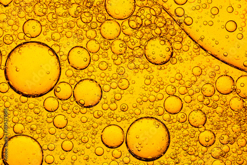 Golden Oil Bubbles in Water Macro Abstract Background,A detailed macro shot of golden oil droplets of various sizes floating in water, creating a beautiful abstract pattern with liquid texture.