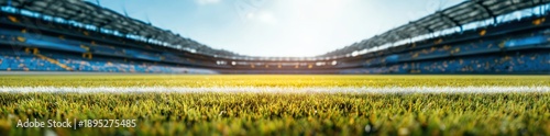 blurred background of an empty soccer stadium with green grass and blue sky
