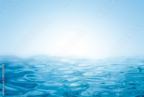 Abstract blue ocean water surface with soft light on horizon, clean water texture background