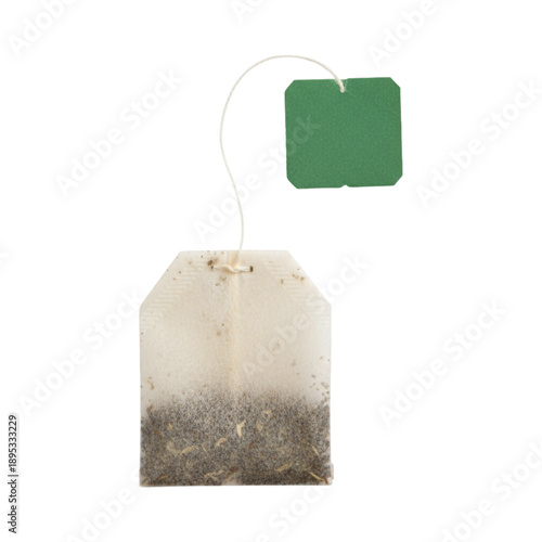Single used tea bag with attached string and small green paper tag isolated against a bright white background
