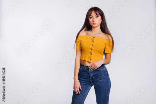 young woman in jeans and blouse posing on white background. stud