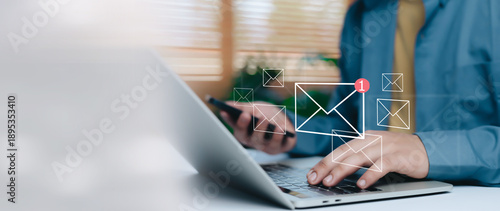 Photos Business professional working on laptop and smartphone with virtual email notification icons, concept of inbox email marketing, online communication, digital workflow and modern business technology