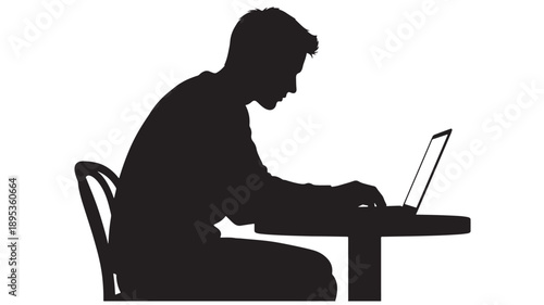 A man sitting at a desk typing on his laptop computer in a focused work environment from a side viewpoint