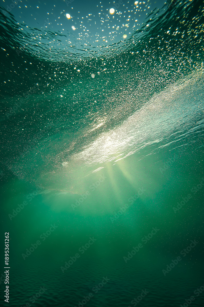 Fototapeta premium 水中から見上げる太陽の光と無数の気泡の背景