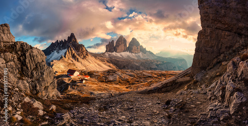 Photos Golden hour panorama of Tre Cime di Lavaredo mountain peak with mountain hut dur