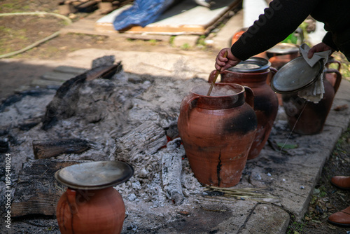 Traditional Portuguese stew cooking in clay pots over an open fire in Alentejo, Portugal. Rustic rural food preparation showing heritage, culture and old cooking methods.
