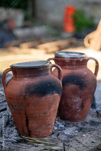 Traditional Portuguese stew cooking in clay pots over an open fire in Alentejo, Portugal. Rustic rural food preparation showing heritage, culture and old cooking methods.