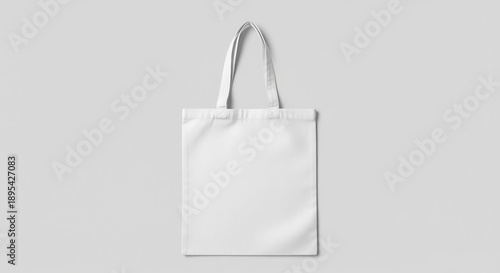 A blank white canvas tote bag with sturdy handles on a gray background. Clean, minimalist design perfect for branding, shopping, or everyday use. Ideal for mockups and promotional campaigns.