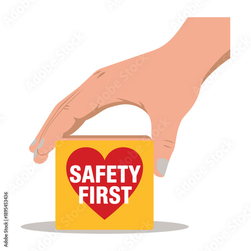 A hand holding a yellow box with a red heart and the words 'SAFETY FIRST' on it.