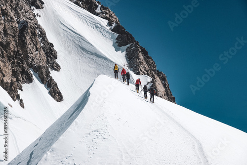 Fotografie Two climbing teams ascend Mont Blanc in perfect weather on the final steep snow slopes near the summit