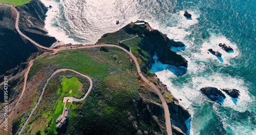 Green rock with the house on top at the shore of the ocean. Drone footage over the splendid coast of Big Sur, California, USA.