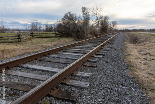 Railway tracks running into the distance in early spring. Rural railroad line.