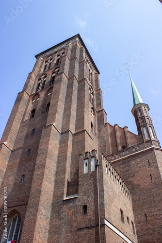Gothic brick church tower against clear blue sky