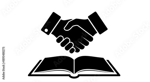 Handshake over an open book symbolizing agreement and partnership.