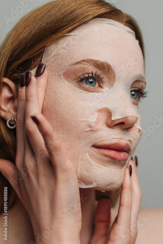 White woman adjusting sheet mask, beauty influencer closeup