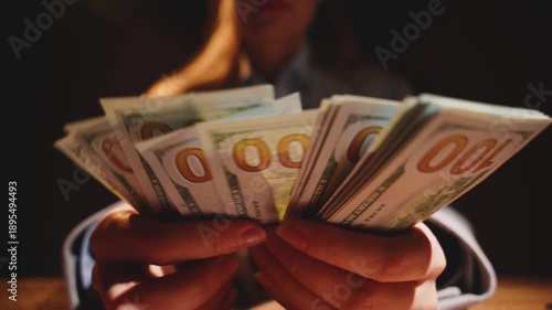 shadow silhouette person counting money, close-up hands holding fan of dollar bills. Concept high taxes. fraud counts cash for profit money laundering investment scam bribe corruption. night dark room