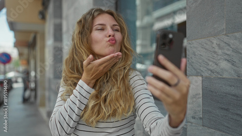 Wallpaper Mural Woman holds smartphone while waving down a street before taking a selfie with a blonde young smiling kiss outdoor vibe. Torontodigital.ca
