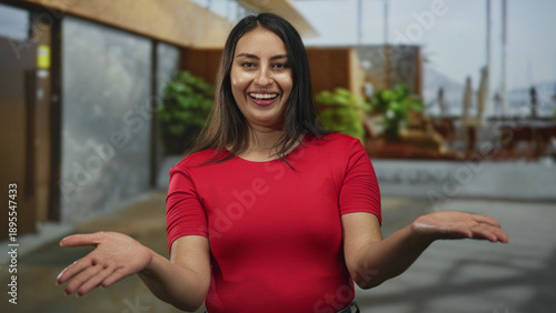 Woman extends hand for handshake at building entrance in red shirt and jeans, facing camera; welcome trust. Free Download Woman extends hand for handshake at building entrance in red shirt and jeans, facing camera; welcome trust. - GFXLoad