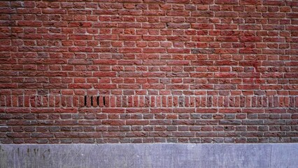 Textured red brick wall with unique patterns and natural imperfections creates an urban industrial style background perfect for design or architectural projects.