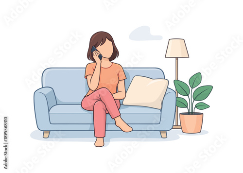 Woman talking on the phone while seated on a sofa with a lamp and plant nearby