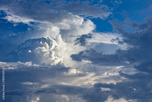 Dramatic dark and stormy cumulus clouds with blue sky in the background. Possibly cumulus congestus  or cumulonimbus. During summer thunderstorm season in Arzona. 
