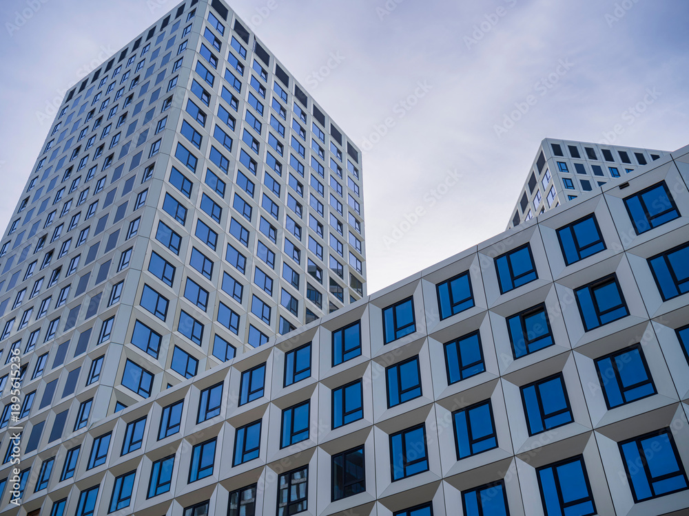 Obraz premium Modern white tower buildings with geometric facade pattern, contemporary architecture