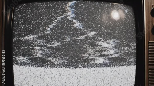Vintage TV screen shows static filled snowstorm with bright sun