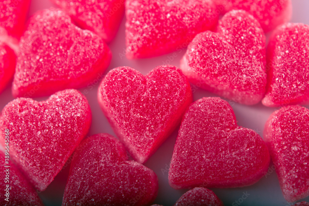Obraz premium Top view of heart-shaped gummy candies covered in sugar crystals