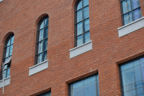 Classic arched windows on a red brick building facade with modern architectural details