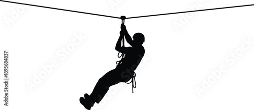 Black Silhouette of a Person Ziplining on a High Wire Cable Wearing a Helmet and Harness for Extreme Sports Adventure and Outdoor Recreation