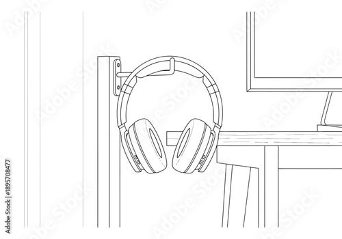 Over ear audio accessory hanging on wall mount adjacent to computer desk setup for listening or performance