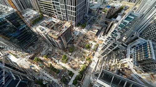 Aerial view of a bustling construction site surrounded by modern skyscrapers in an urban landscape