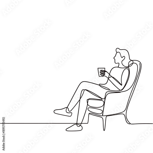 A woman relaxes in a chair enjoying a warm beverage in solitude