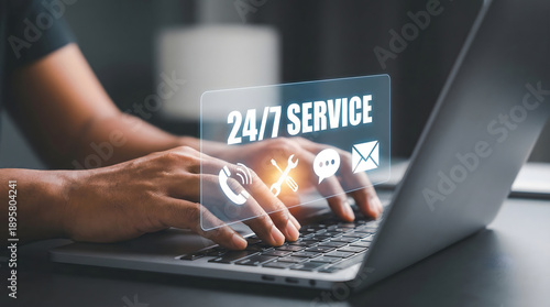 Hands typing on a modern laptop keyboard indoors with a bright digital interface displaying 24 7 Service alongside various communication and support i